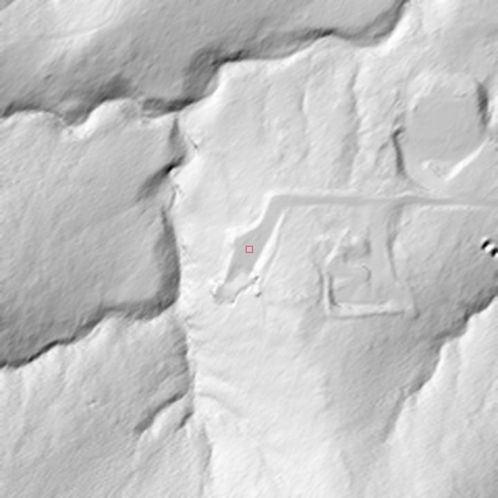 Grayscale 1-metre hillshade close-up of the graded lot: drainage lines, berms and boulders resolved from the bare-earth point cloud.